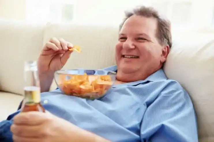man eating junk food while watching tv