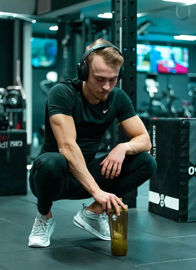 man in gym listening to momentum membership program on headphones